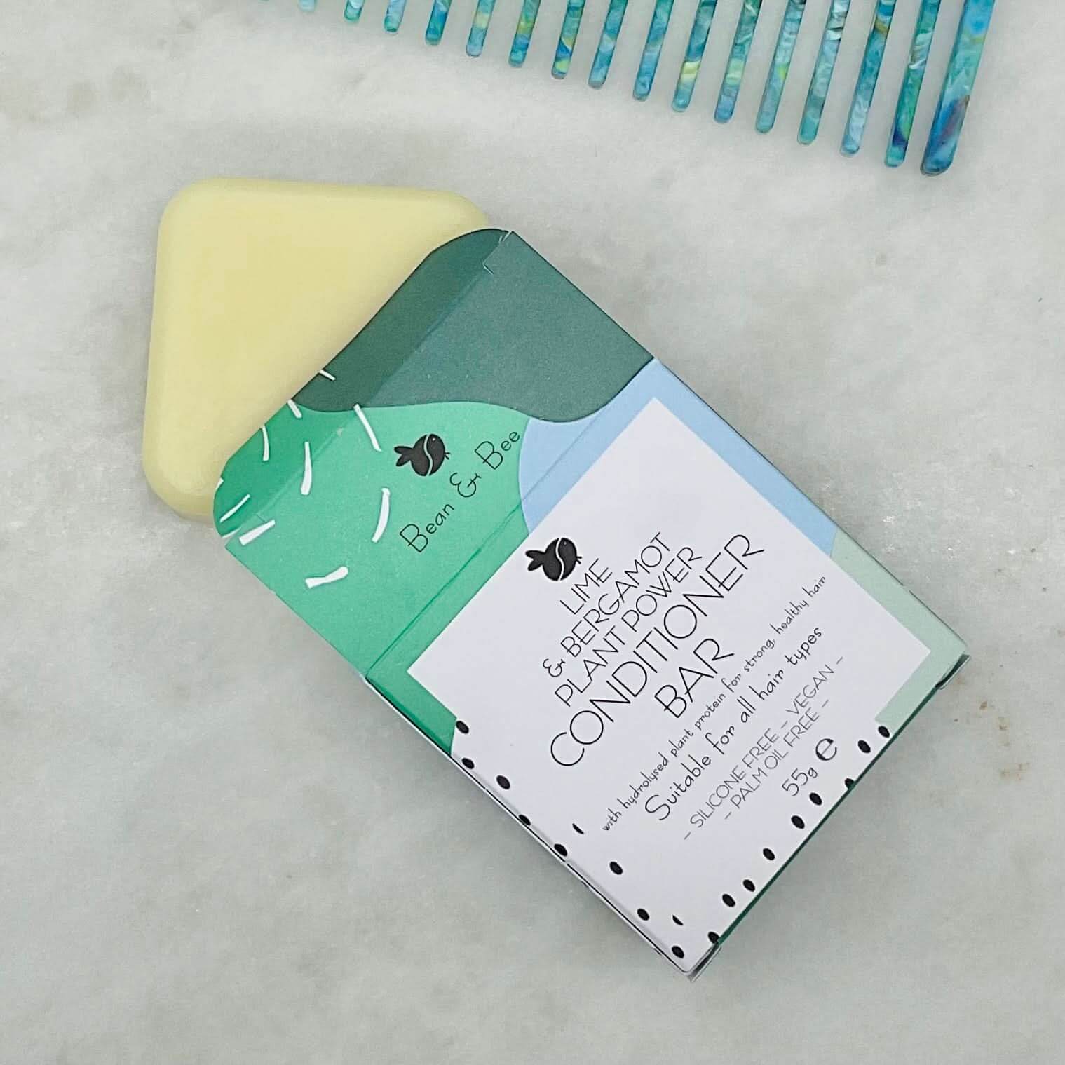 Plastic-free conditioner bar from Bean & Bear for hydrated, frizz-free curls on a marble surface.