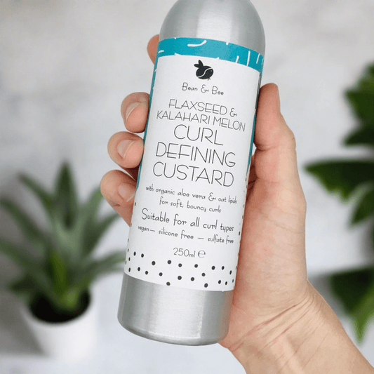 Flaxseed and Kalahari Melon curl defining custard for soft, bouncy curls in a sleek aluminum bottle.